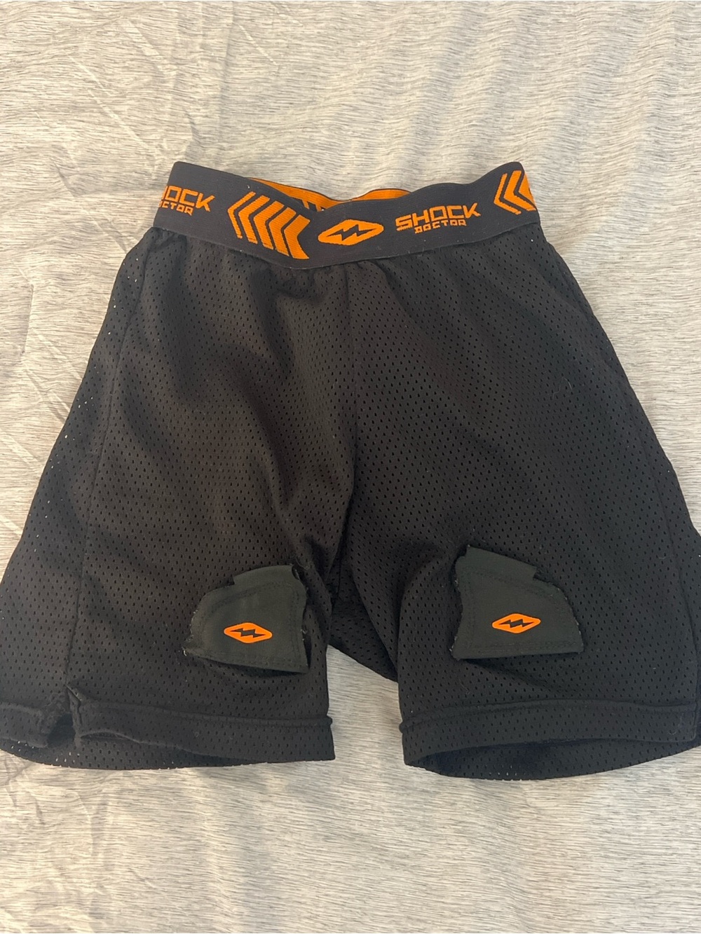 Youth Black Protective Hockey Shorts with Orange Accents